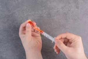 pessoal segurando seringa para aspiração e remédio intramuscular