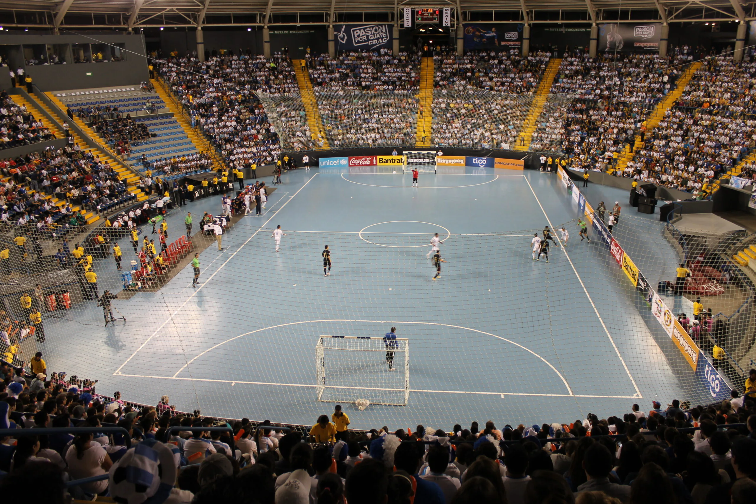 Jogadores disputando uma partida de futsal em quadra