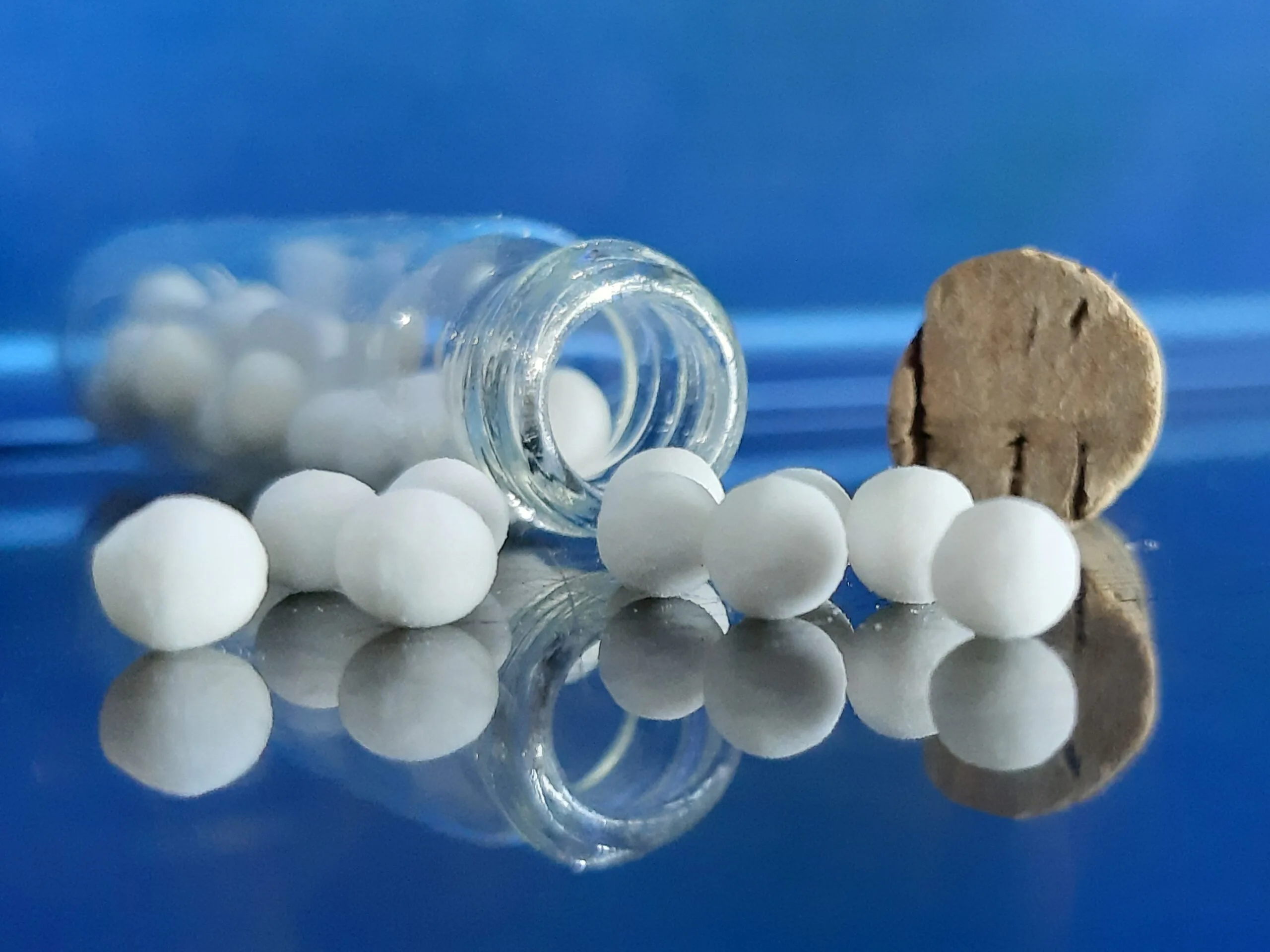 Pequenos glóbulos brancos usados em preparações homeopáticas, vistos de perto.
